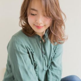 ゆるウェーブをかけたセミロングヘアの女性の写真