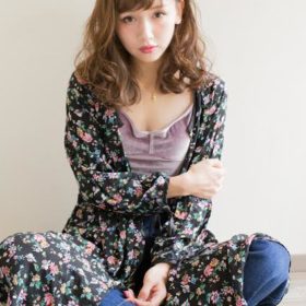 前髪を横に流したロングパーマヘアの女性の写真