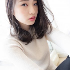 メロのトップを立ち上げた透明感のあるミディアムヘアの女性の写真