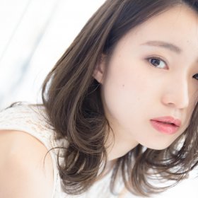 メロのゆるくウェーブがかったミディアムヘアの女性の写真