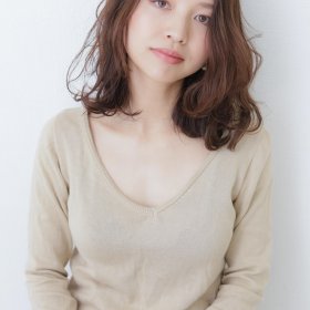 メロのウェイトを下に持たせた大人っぽいミディアムウェーブの女性の写真