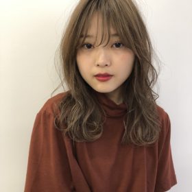 毛先にカールのついたアッシュベージュのロングヘアの写真