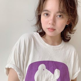 セパレートの前髪で外はねのショートボブパーマの女性の写真