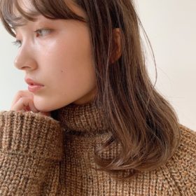 くすんだカラーの毛先パーマをかけたロングの女性の写真