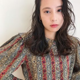 前髪なしでロングヘアのパーマをかけた女性の写真