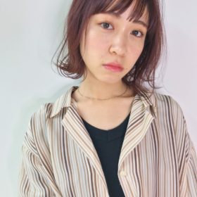 少しピンクがかった外はねボブの女性の写真
