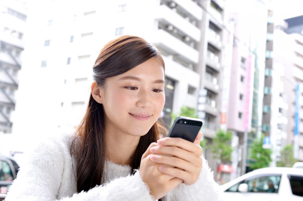 スマートフォンを見る女性の写真