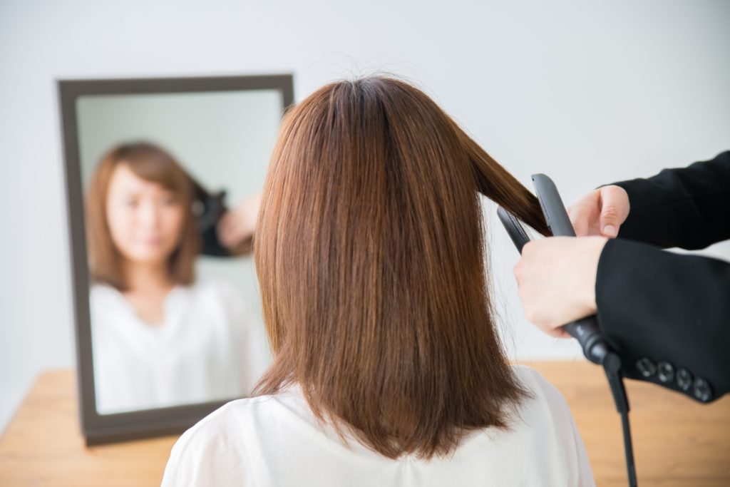 コテ巻きをする女性の写真