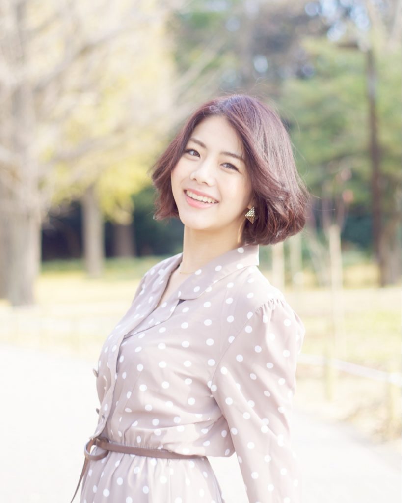 屋外で撮影された前髪がセパレートのエアリーボブの女性写真