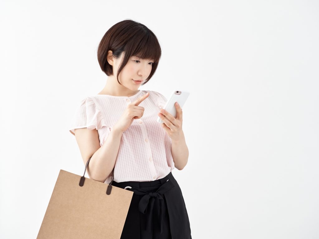 スマホで買い物をする女性の写真