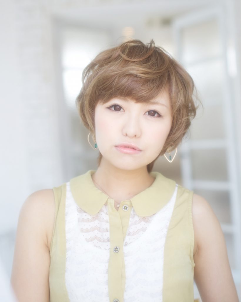 ブラウンヘアのニュアンスパーマのカジュアルショートの女性の写真
