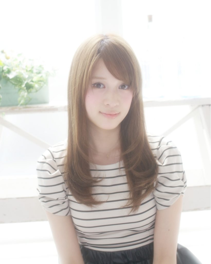 縮毛矯正をかけたブラウンカラーのロングヘアの女性の写真