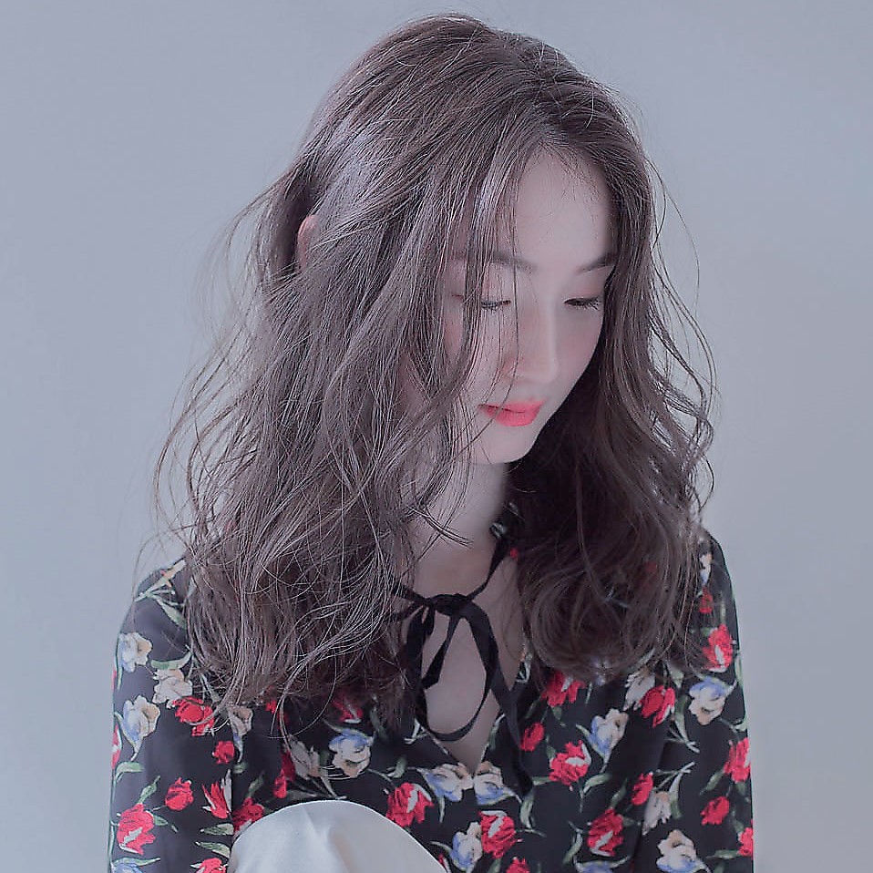 ツヤツヤなウェーブヘアの女性の写真