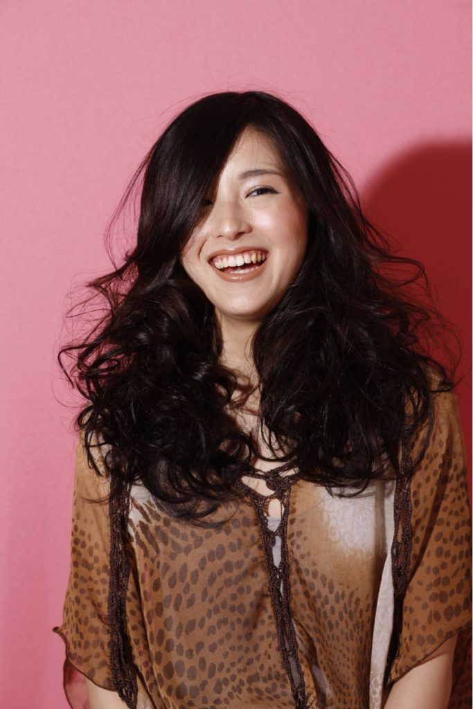 パーマがかかったロングヘアスタイルの女性の写真