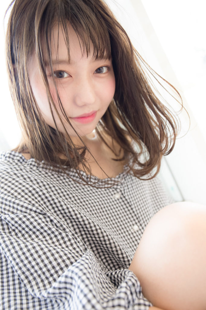 透明感のあるヘアカラーのミディアムヘアの女性の写真