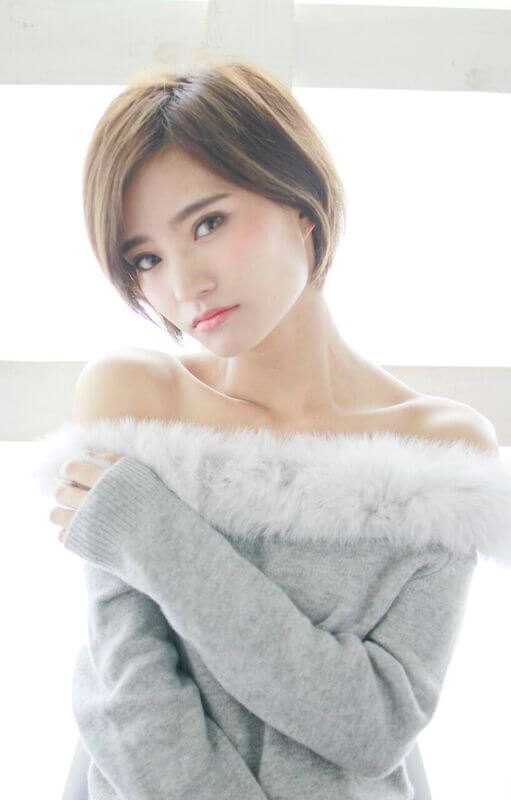 肩出しトップスのショートヘアの女性の写真