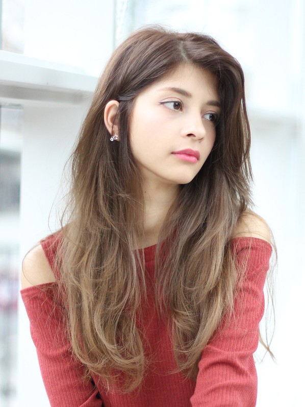右を向くロングのグラデーションヘアの女性の写真