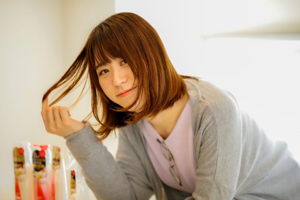 毛先をつまむ女性の写真