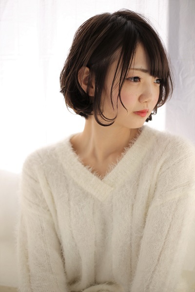 タリーテーブルの耳にかけたボブスタイルの写真
