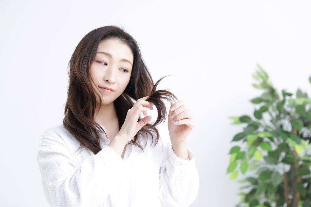 毛先を見る女性の写真
