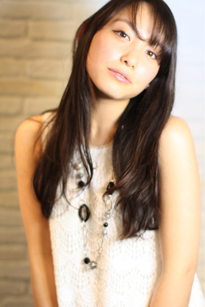 毛先にゆるいパーマがかかったロングヘアの女性の写真