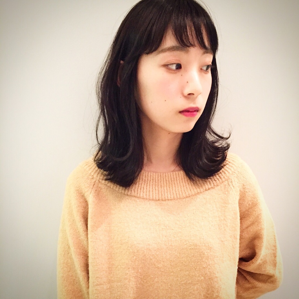 オレンジ色のセーターを着たミディアム黒髪女性
