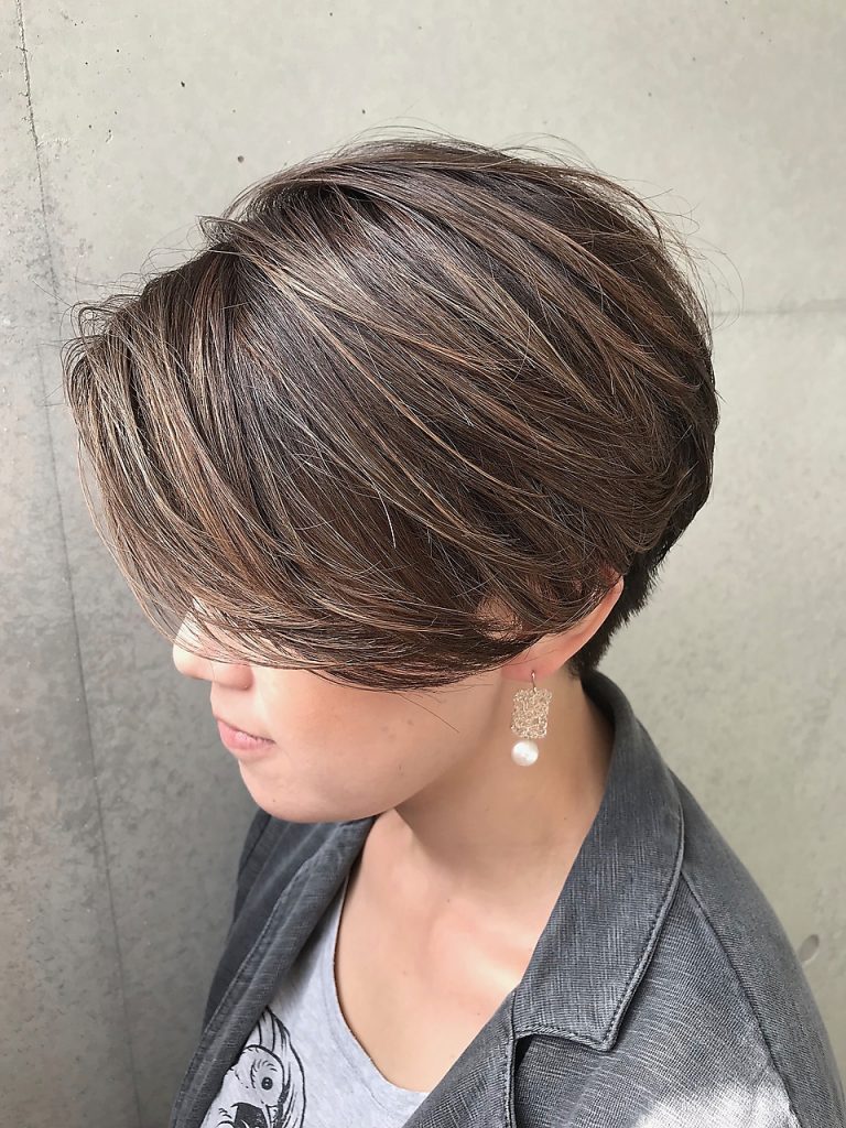 アッシュグレーショートヘアで上着を着た女性