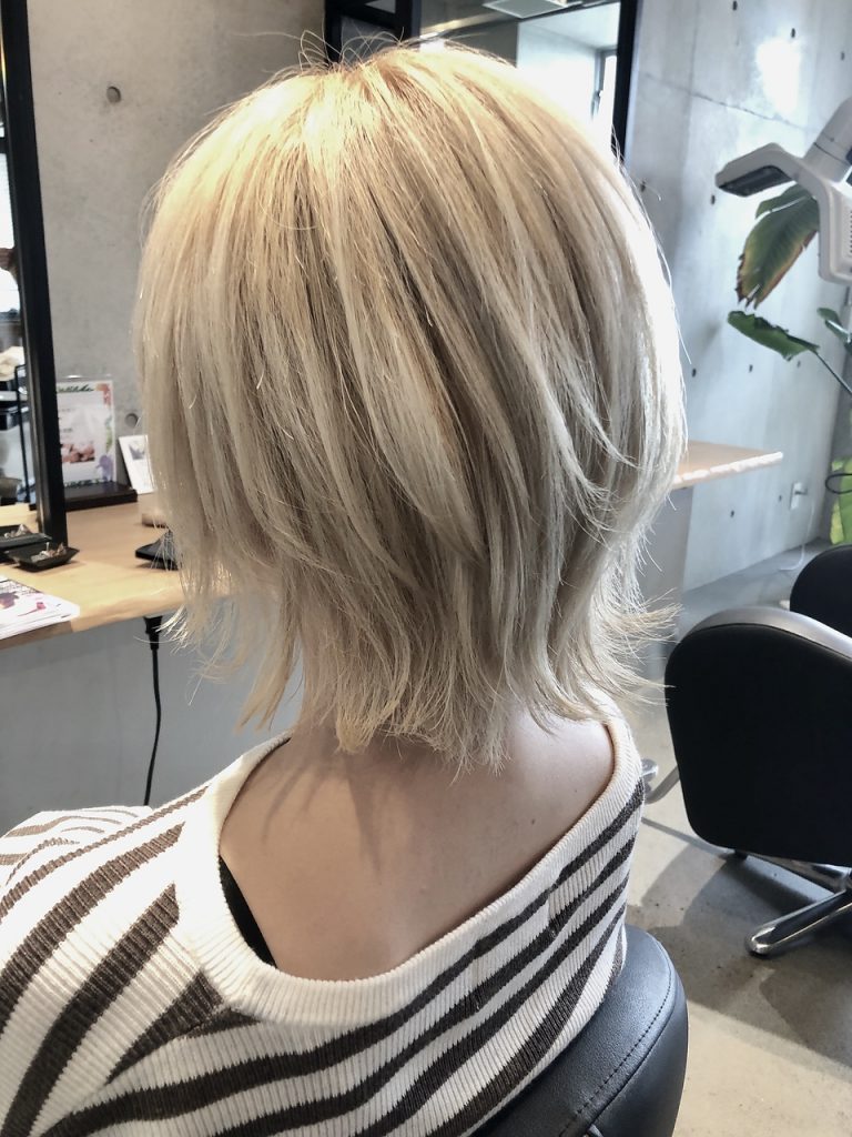 ブリーチを重ねて淡いクリーム色のショートヘア女性後ろ姿