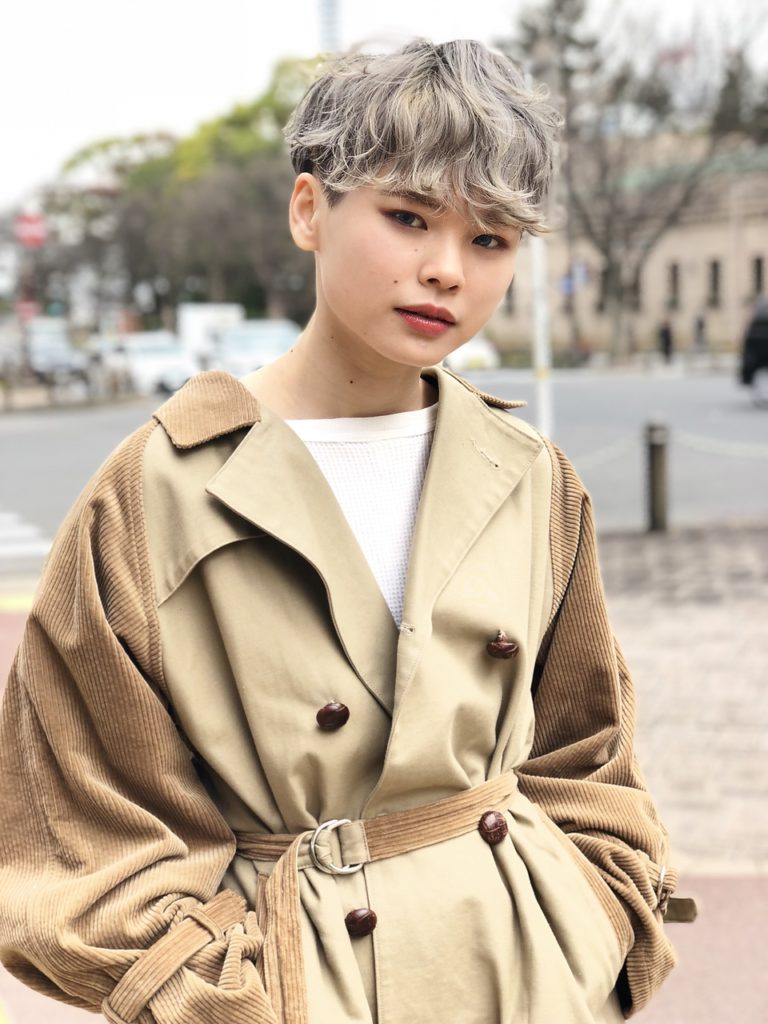 トレンチコートを着たショート丈のグレイヘアのオシャレ女性の様子