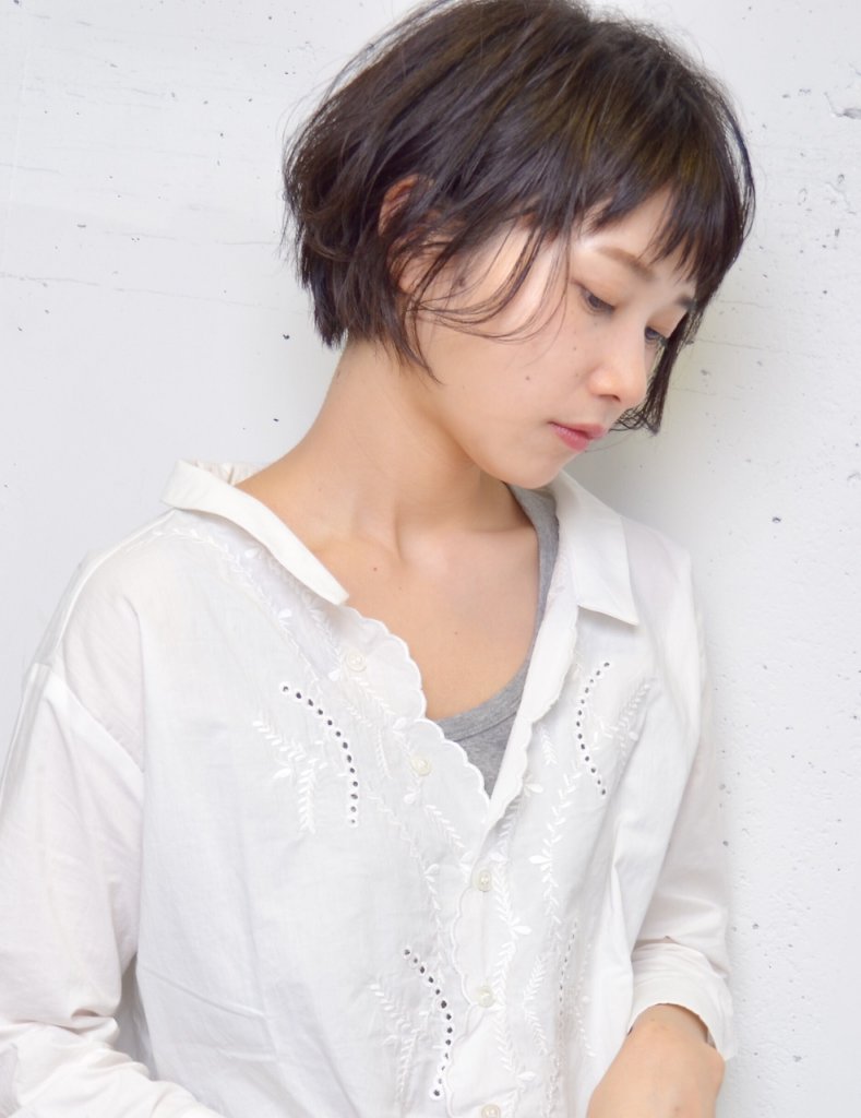 うつむくショートヘア女性