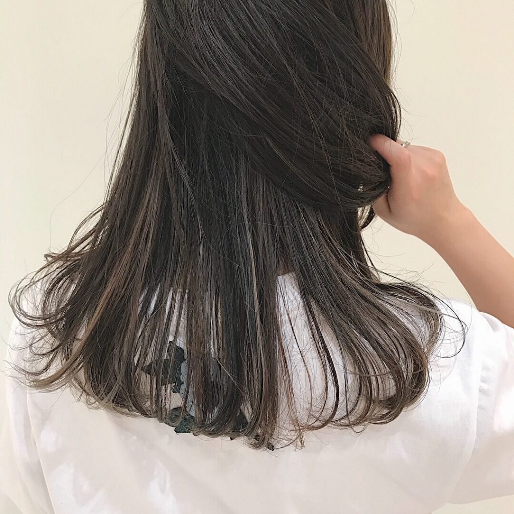 ハイライトのラインを入れたロングヘアTシャツを着た女性