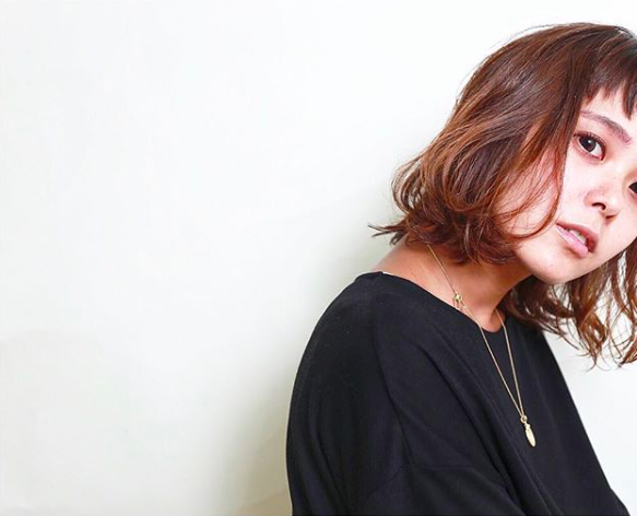 黒いシャツを着たブラウン色のショートヘア女性