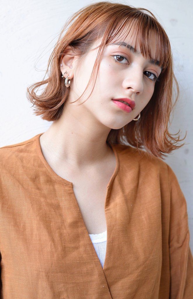 マリーゴールドボブヘアのアンニュイな女性