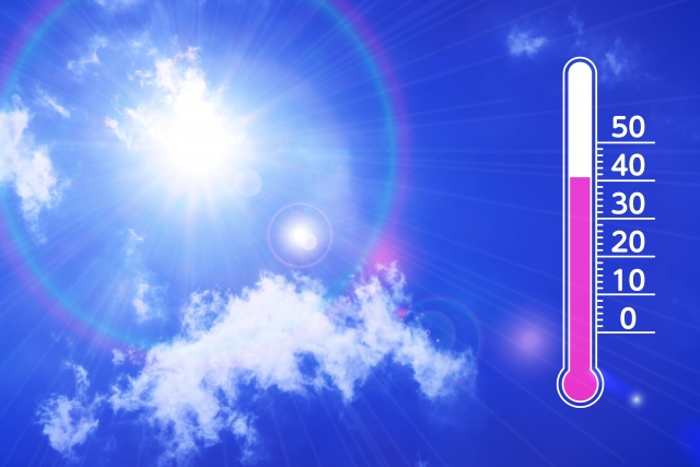 青空に輝く真夏の太陽と温度計