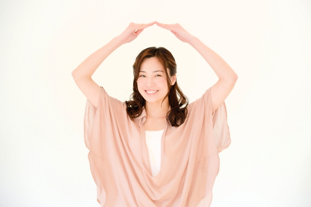 笑顔の女性が両腕を上にあげて大きな丸を作る様子