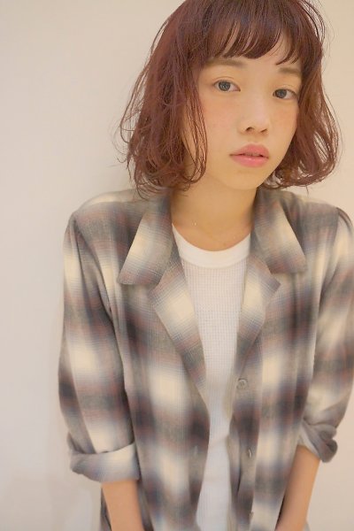 ナチュラル系ボブヘアの大柄チェック柄シャツ着た女性の写真