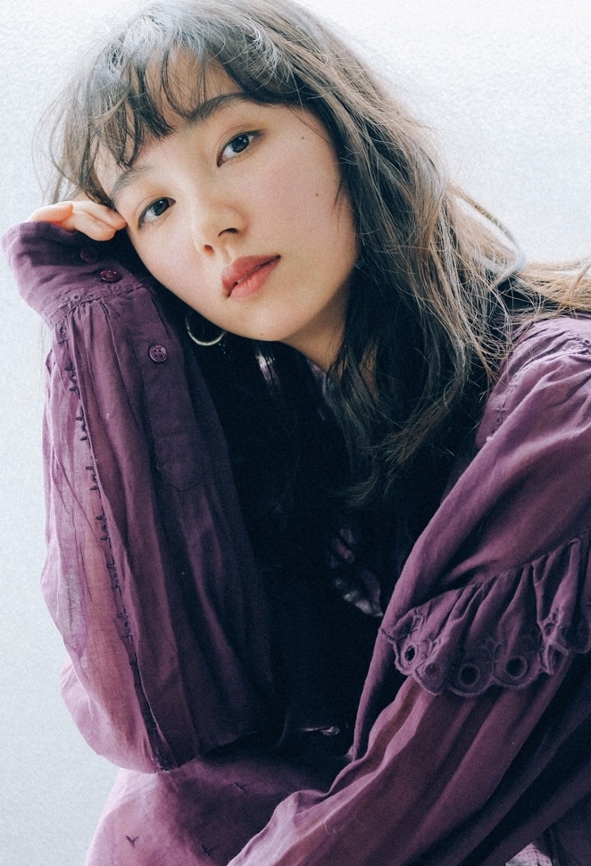 ロングのストレートヘアスタイルの紫色のセーターを着た女性の写真