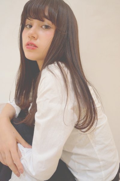 ストレートロングヘアのフェミニンな女性が振り向く様子の写真