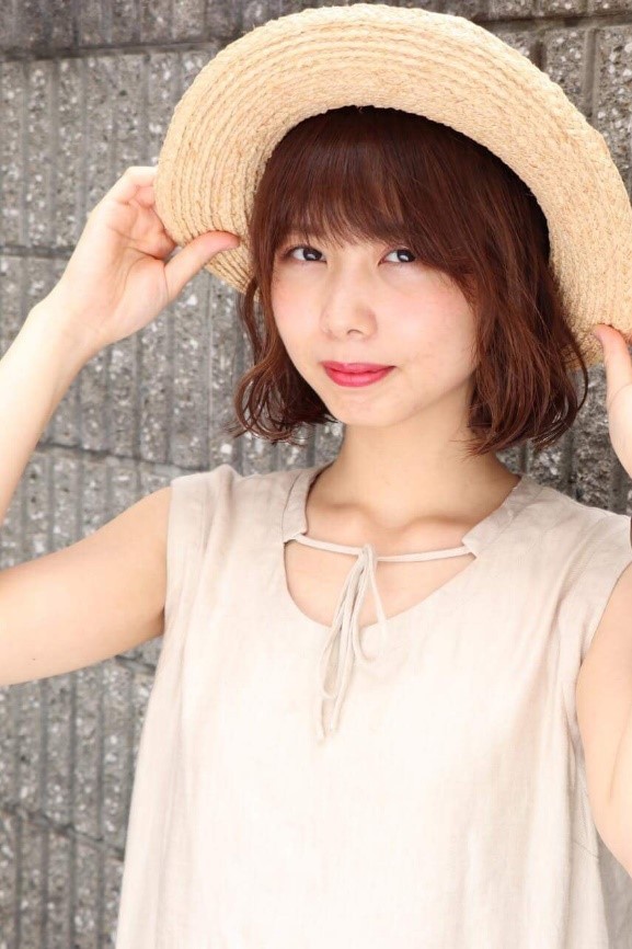 バカンススタイルではにかみ笑顔のナチュラルブラウンミドルヘアの女性