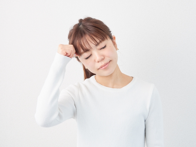 白いシャツを着た女性が悩み事をしている様子