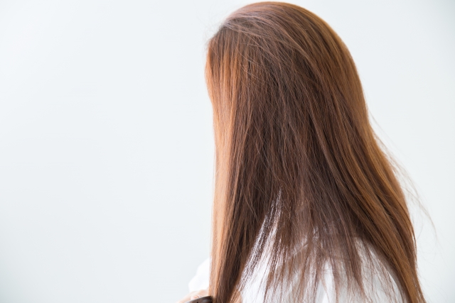 毛先の傷んだ髪を丁寧に梳かす美しい女性