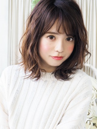 ナチュラルショートボブの女性が少し上目遣いで見ている様子