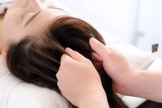 横になり頭皮をヘッドスパで癒されている女性の様子