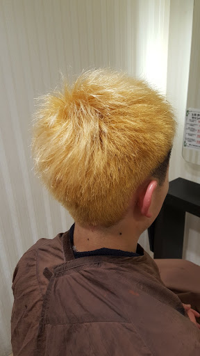 輝くゴールド色したショートヘア男性の後姿