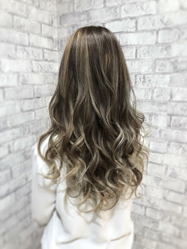 太めのハイライトの入ったロングウェーブヘア女性のイメージ