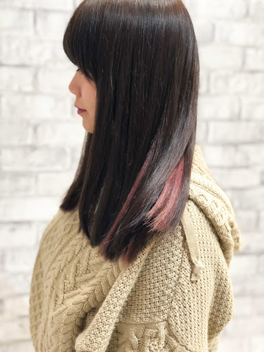 インナーカラーに赤系の入れたロングヘア女性の振り向き様