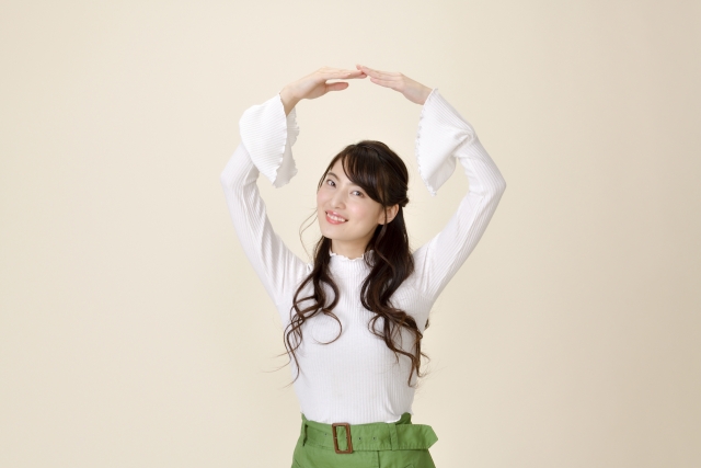 白いオシャレシャツを着た女性た腕でOKを作る様子