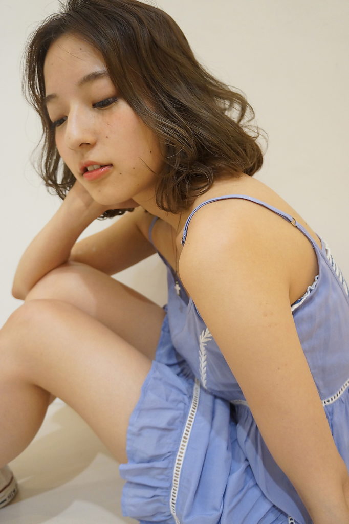 デニム調のワンピースを着たボブヘアの女性