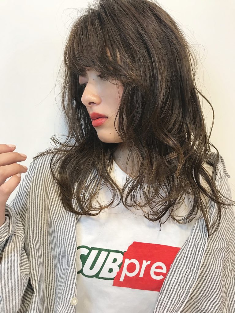 ミックスパーマでアンニュイな雰囲気の若い女性横顔