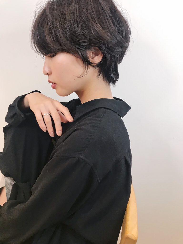 黒いシャツを着たトップふんわりショートヘア女性の横顔